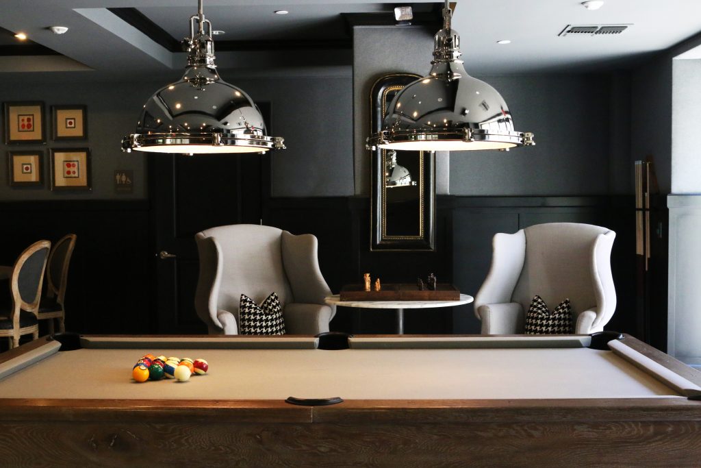 a basement renovation with a game room and sitting area that includes a billiards table.