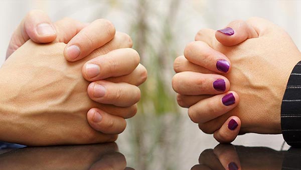 Photo showing the hands of a couple that is negotiating their mortgage after divorce.