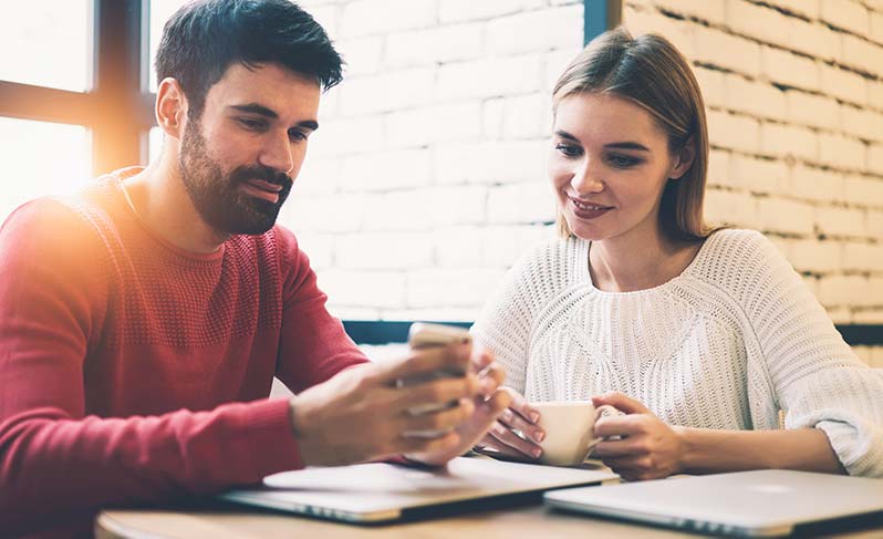 A couple that is figuring out ways they can afford the closing costs on a mortgage over coffee.