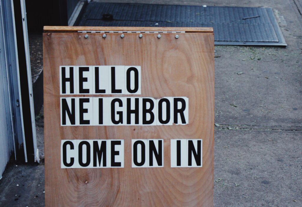 Good Neighbor Program, wooden sign says "hello neighbor come on in" 