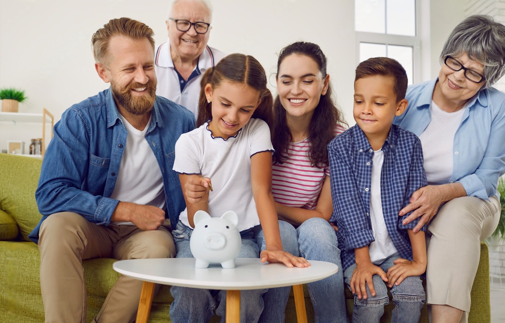 Family Member sitting on a couch looking at a piggy bank